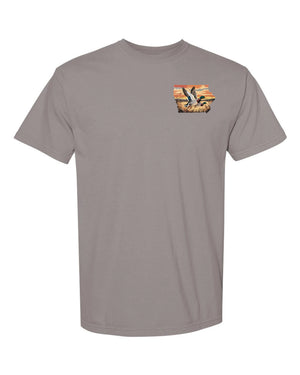 Front pocket of Iowa Duck Hunting T-Shirt featuring small Iowa state outline with flying ducks, Comfort Colors outdoor hunting tee for Iowa waterfowl enthusiasts.